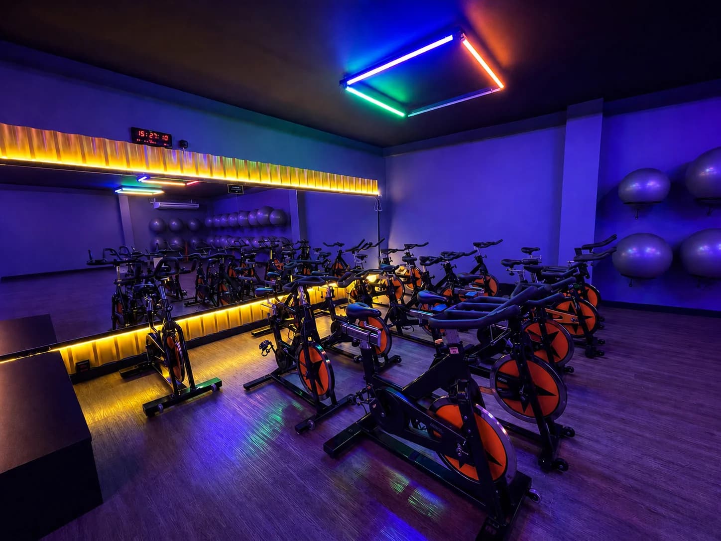 Sala de spinning com bikes indoor e iluminação neon na Loud Fit Mogi Mirim