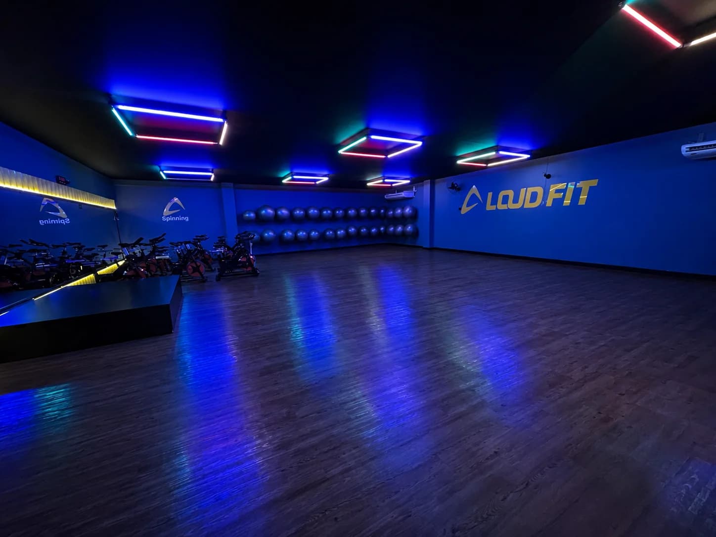 Sala de aulas coletivas com piso de madeira e iluminação LED na Loud Fit Mogi Mirim