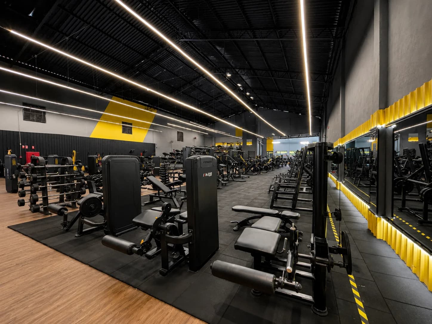 Área de peso livre com halteres e bancos na Loud Fit Vila Industrial